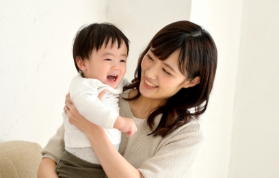 笑顔で赤ちゃんを抱っこする母親