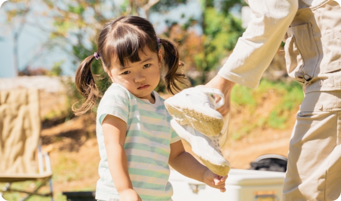 外で遊んでいる女の子と支援者の様子